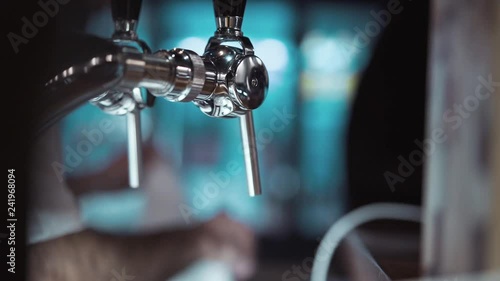 Close-up. Beer tap. Pouring beer in the bar. Compensatory tap for beer. Blurred bar background. Bar counter photo