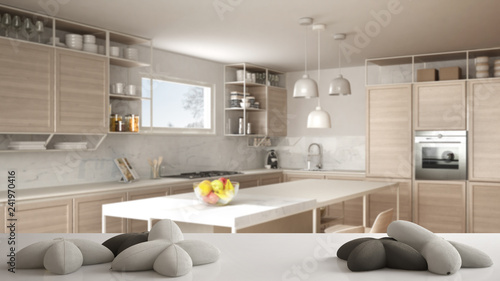 White table, desk or shelf with five soft white pillows in the shape of stars or flowers, over blurred modern wooden kitchen, white architecture interior design concept