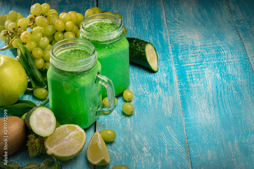 Healthy green vegetables smoothie in the jar on rustic wooden background Healthy green vegetables smoothie in the jar on rustic wooden background