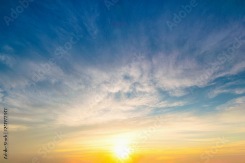 Sky blue and orange light of the sun through the clouds in the sky