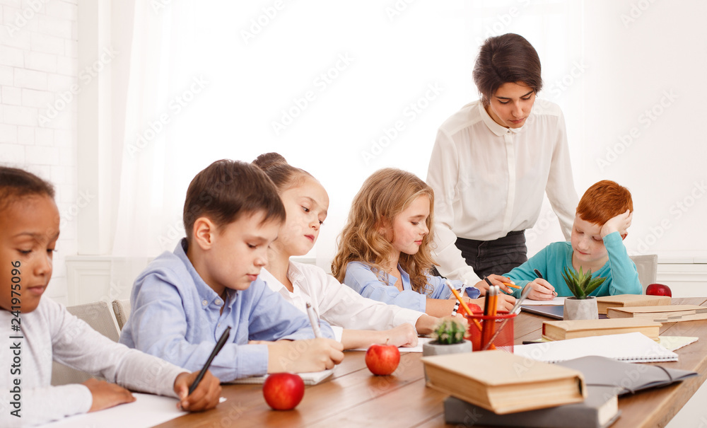 School kids doing homework with teachers help