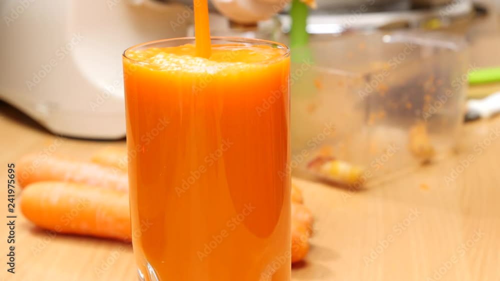 Pouring fresh squezzed carrot juice iinto glass. Healthy food, natural source of vitamin a. Slow motion Pouring fresh squezzed carrot juice iinto glass. Healthy food, natural source of vitamin a. Slow motion
