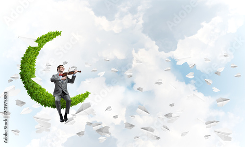 Handsome businessman play his melody and paper planes fly around