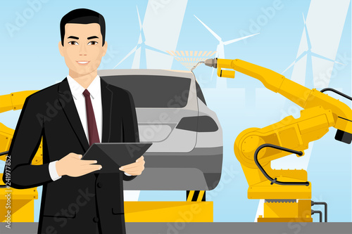 Asian manager with a digital tablet controls the welding robots on the car assembly line.