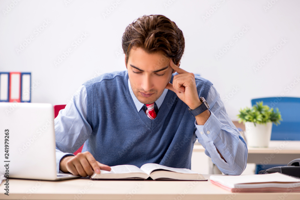 Young handsome employee working in the office Young handsome employee working in the office