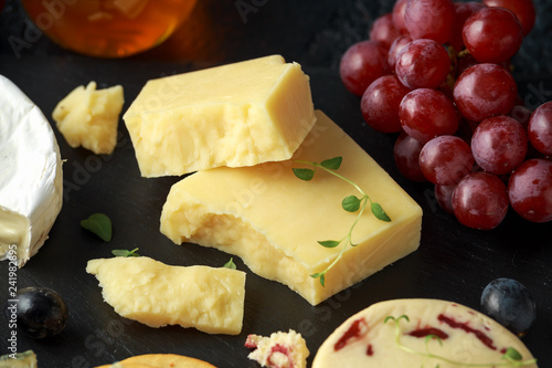 Cuadro en lienzo Cheese platter served with grapes, ale chutney, honey, crackers on stone board