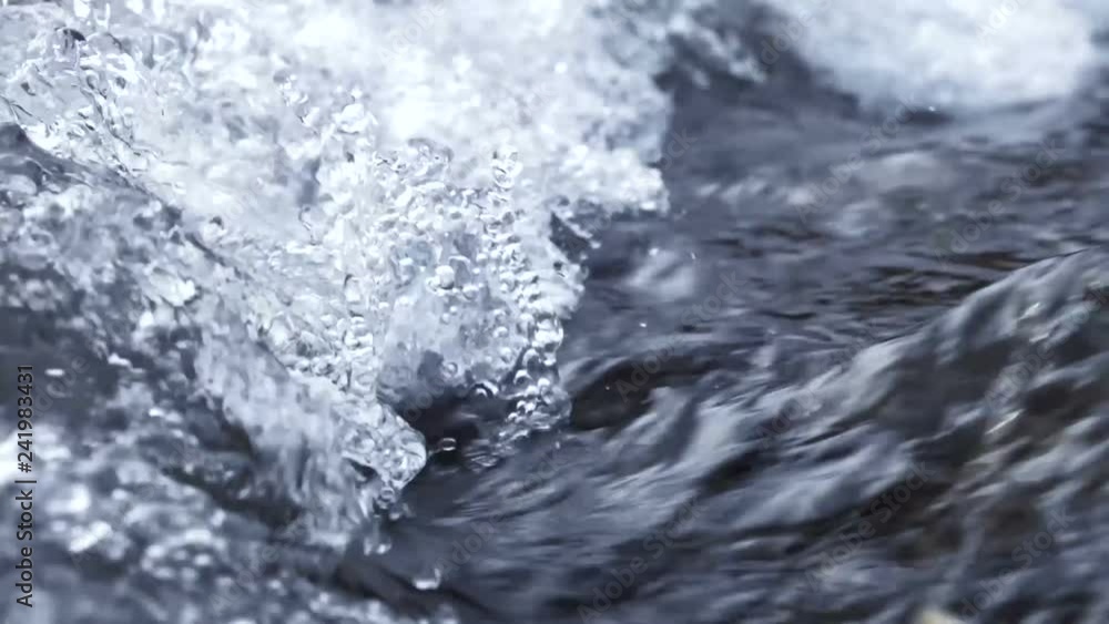 Winter waterfall river close up in slow motion. Crystal water in the mountains. Winter waterfall river close up in slow motion. Crystal water in the mountains.