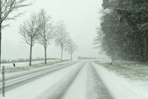 snow storm on a country road and dangerous road conditions in winter