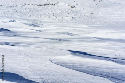 Winter landscape with wind sculpted patterns on snow- wind effect