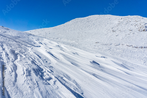 Winter landscape with wind sculpted patterns on snow- wind effect © Haris Andronos