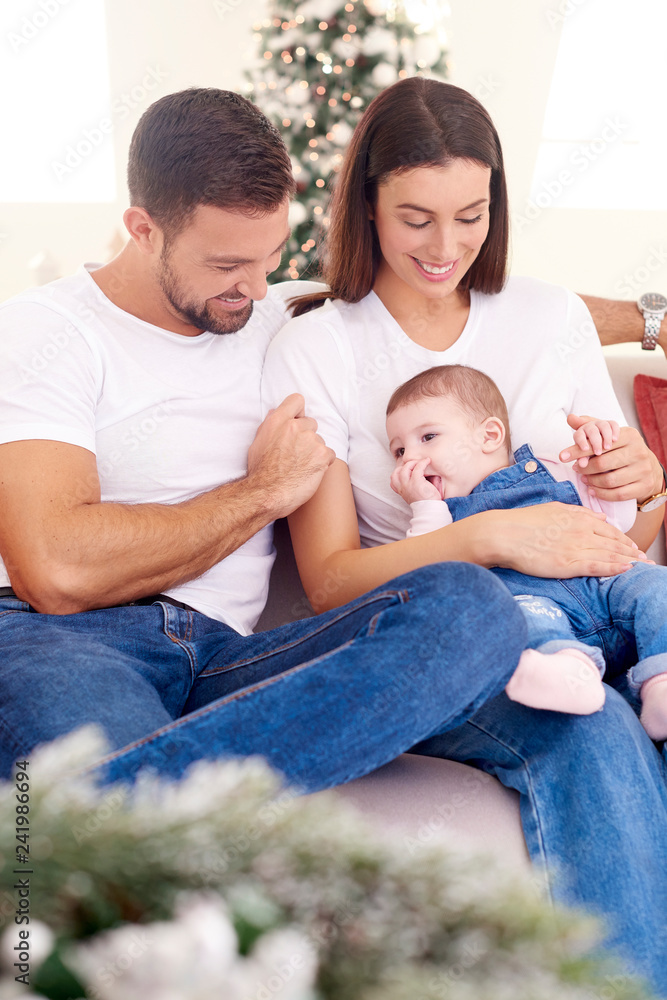 Lovely family with their baby girls relaxing on sofa at home Lovely family with their baby girls relaxing on sofa at home