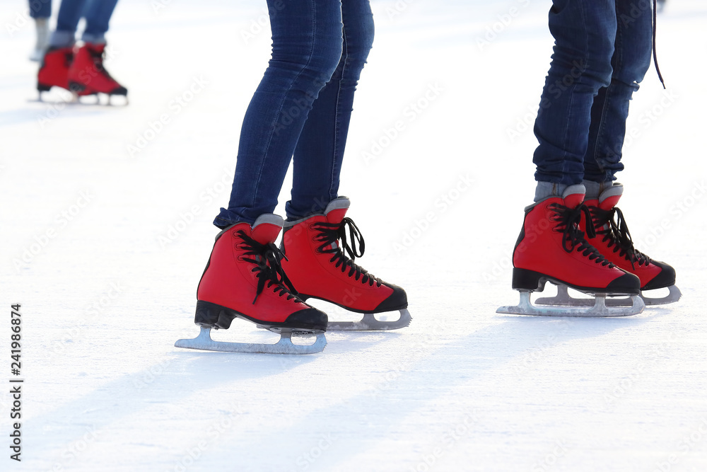 Female legs in skates on an ice rink Female legs in skates on an ice rink