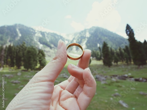 Holding wedding rings in mountain park