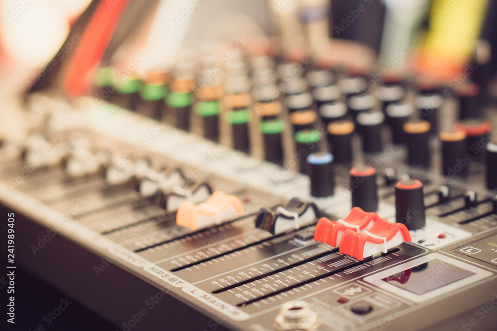 The hand over adjusting knobs on a professional audio mixer for sound mixer control. Selective focus. The hand over adjusting knobs on a professional audio mixer for sound mixer control. Selective focus.