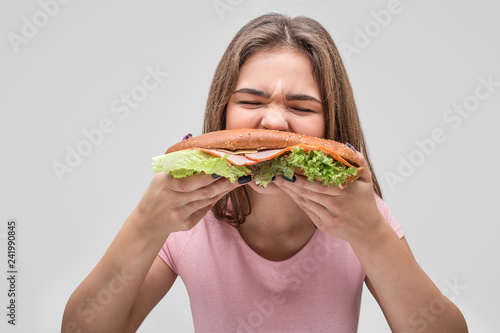 Photos Hungry young woman bite burger