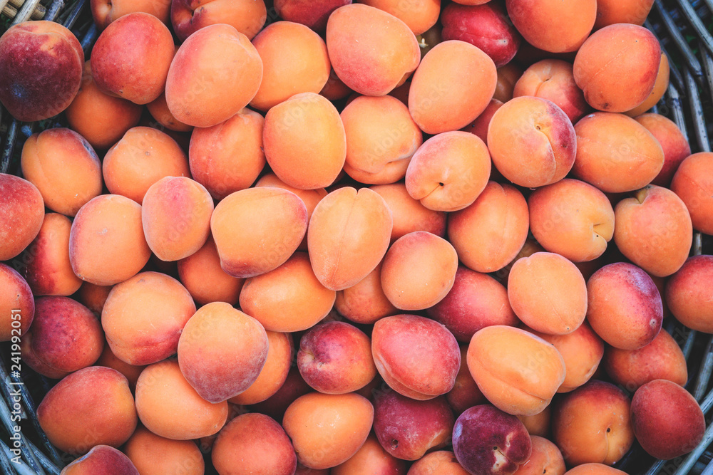 Ripe apricots in a wicker basket on green grass, top view, isolated Ripe apricots in a wicker basket on green grass, top view, isolated