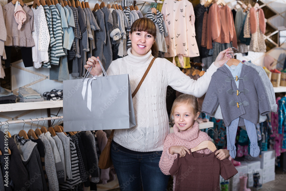 Happy pregnant woman and girl enjoying purchases