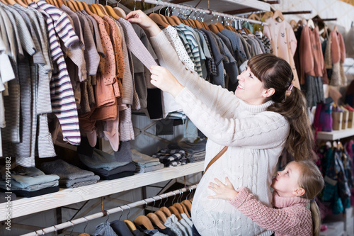 Mother and daughter choose clothes for newborns
