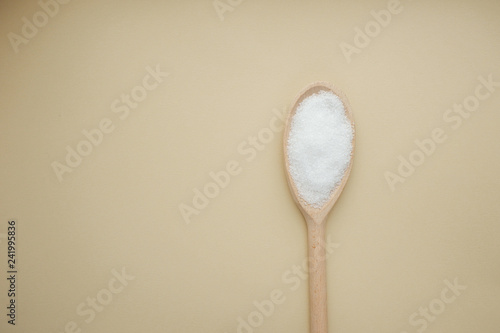 Sea salt in a wooden spoon. Top view with copy space