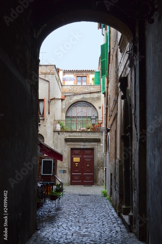 Narrow street in old italian town with restaurant and doors