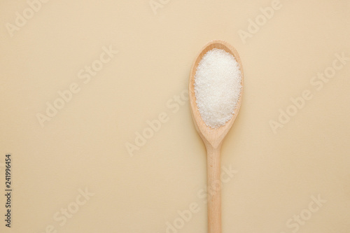 Sugar in a wooden spoon. Top view with copy space