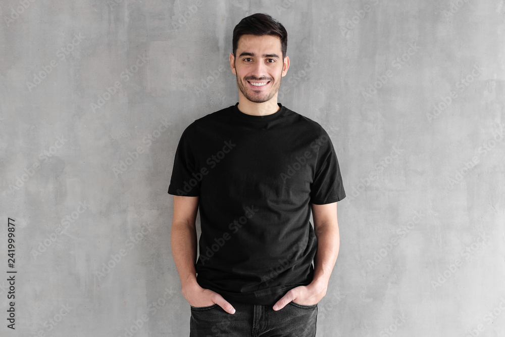 Mock up of young man body in empty black t-shirt isolated on textured gray wall background Mock up of young man body in empty black t-shirt isolated on textured gray wall background