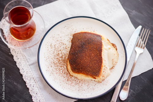 Traditional Turkish dessert Kazandibi with ground cinnamon and turkish tea photo