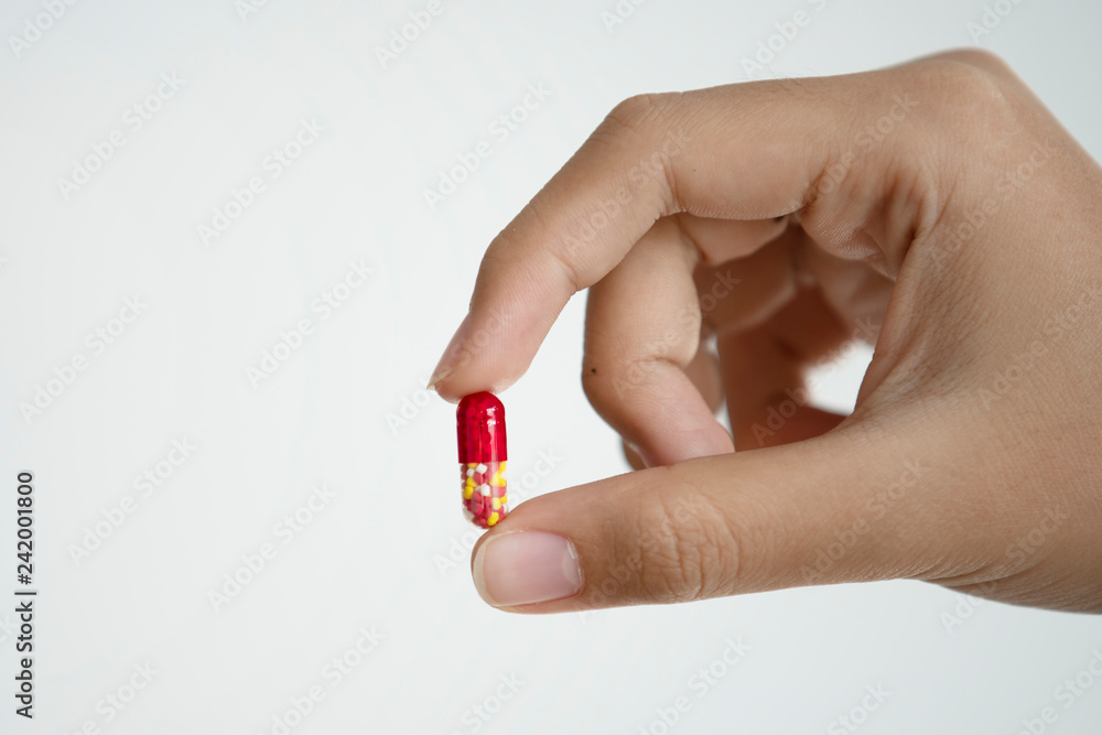 Hand holding medical drug capsule on white background Hand holding medical drug capsule on white background