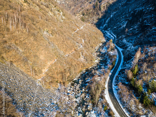 Aerial view of mountain road through wild valley in swiss alps in winter