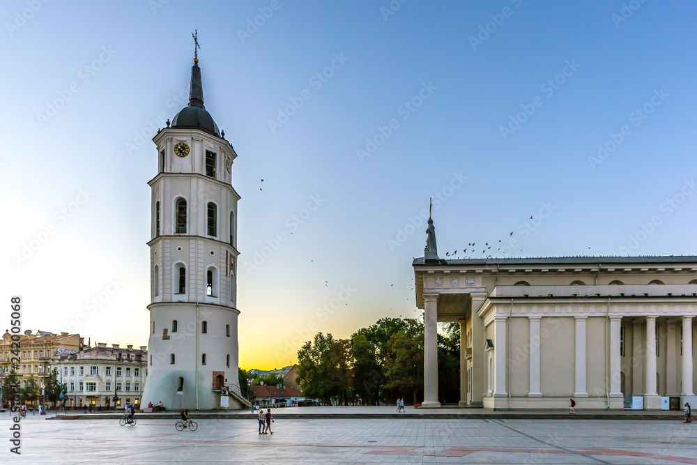 Vilnius, Lithuania - June 20th 2018 - Tourists and locals enjoying a late sunset at Vilnius downtown with a huge church and colorful sky in Lithuania