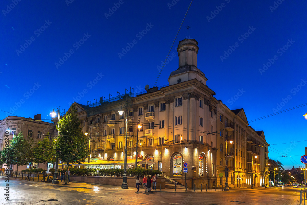 Vilnius, Lithuania - June 20th 2018 - Tourists and locals walking near a historical building in a early night in Vilnius