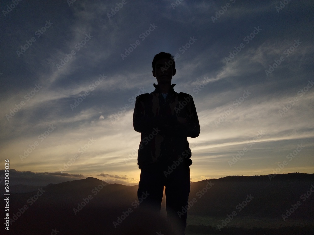 silhouette of man on sunset background of blue sky
