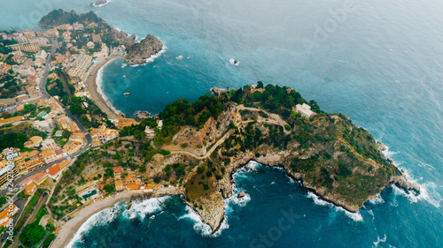 Aerial view of charming coastal Mediterranean small town on Sicily island, Taormina. Beaches of Taormina and south Italy.Travel destination, vacation in Italy concept.Aerial landscape of Bella Isola