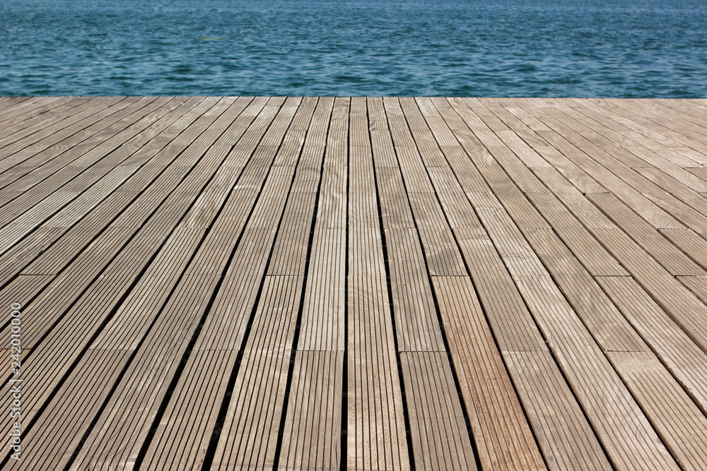 wooden deck floor waterfront shoreline background texture material perspective foreshortening surface to blue water, wallpaper pattern for copy or text - obrazy, fototapety, plakaty 