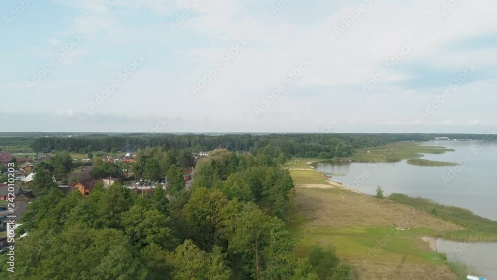 Aerial view of trees in the village, buildings, road, lake, blue beautiful sky, forest Aerial view of trees in the village, buildings, road, lake, blue beautiful sky, forest