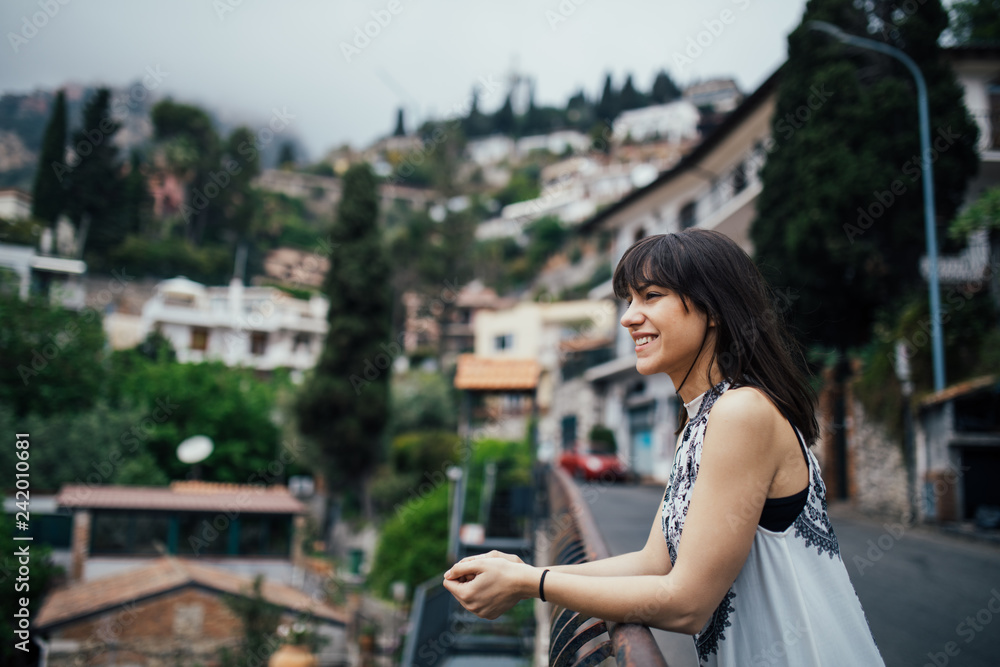 Young woman traveling to Italy.Visiting Taormina,Sicily,Italy.Woman traveler enjoying charming Mediterranean coastal city.Exploring streets