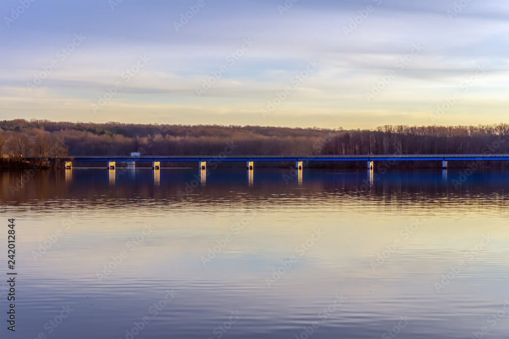 blue bridge over big lake against the evening sky