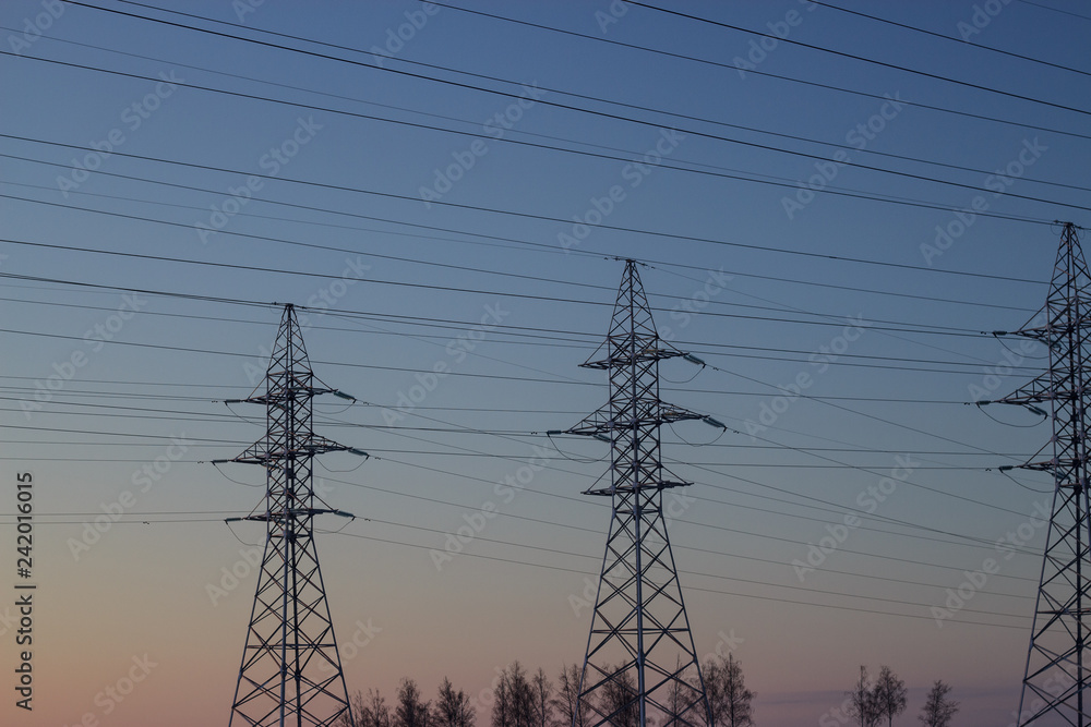 Fototapeta premium Electricity poles on the background of a winter sunset sky.