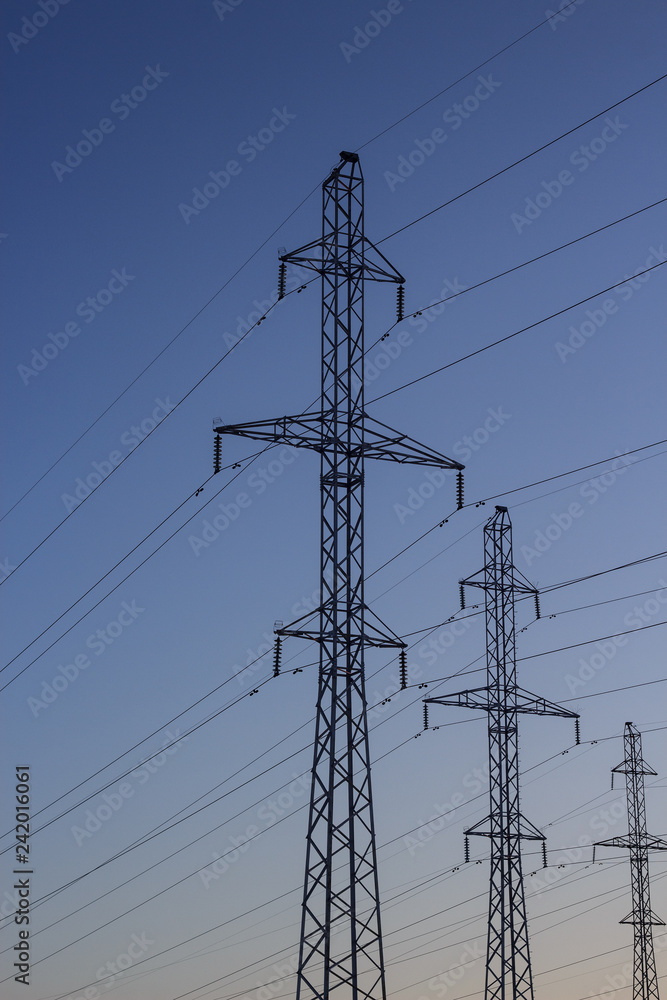 Power lines in winter. Poles of power lines on the background of a winter sky. Copy space. Power lines in winter. Poles of power lines on the background of a winter sky. Copy space.