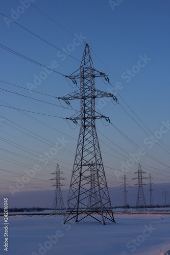 Power lines in winter. Poles of power lines on the background of a winter sky. Copy space.