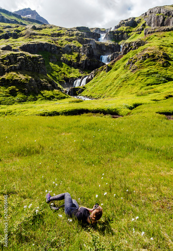 Women in laying down position is photographing  Klifbrekkufossar waterfall photo