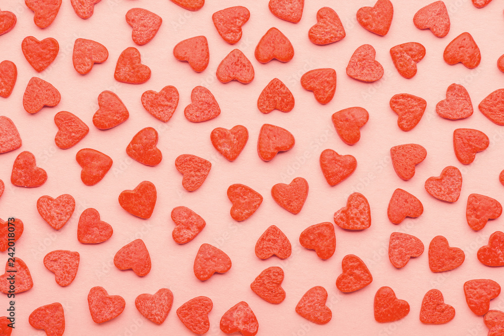 sweet sprinkles of heart shapes over pink background, concept of St. Valentines Day, trendy color living coral sweet sprinkles of heart shapes over pink background, concept of St. Valentines Day, trendy color living coral