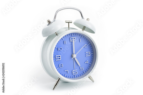 Twin bells analogue alarm clock with blue clock face shows five hours, 5 AM PM; concept on white background
