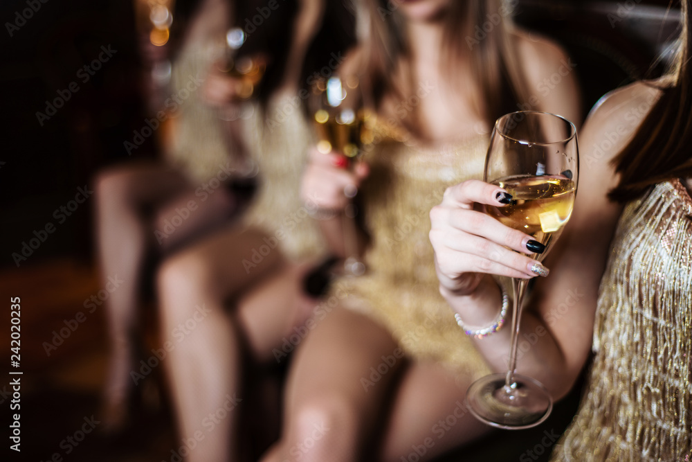 Women's hands holding glasses of champagne. Wine in a glass closeup.
