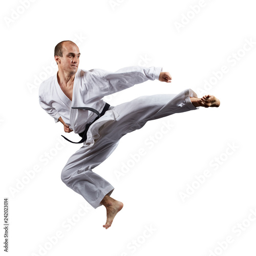 In jump athlete is doeing kicks on an isolated white background.