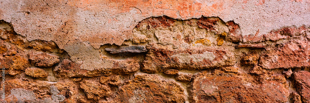 brick wall covered with old crumbling cement plaster with traces of paint. brick wall covered with old crumbling cement plaster with traces of paint.