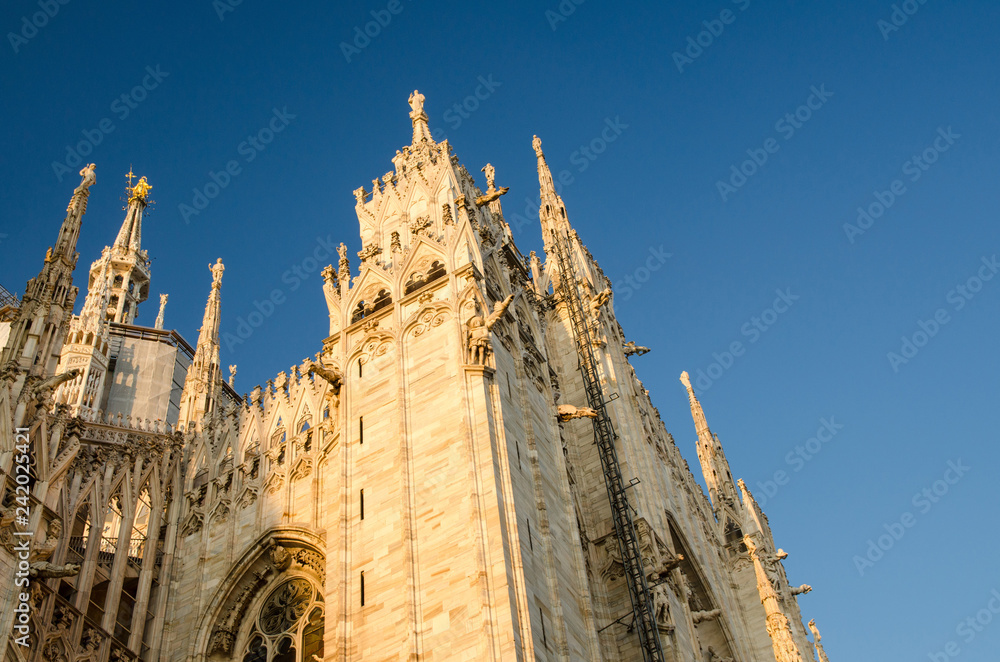 White walls of Duomo di Milano cathedral with high windows, Italy