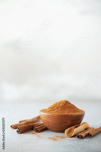 Cinnamon sticks and powder on grey background. Spices for ayurvedic treatment. Alternative medicine concept