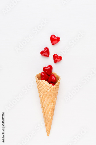 Creative composition for Valentines day with waffle cone, mixed hearts on white background top view. Fashion flat lay. © gitusik