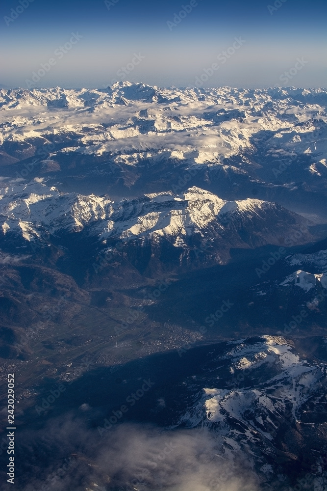 Fototapeta premium Swiss Alpes with snowy mountain tops aerial